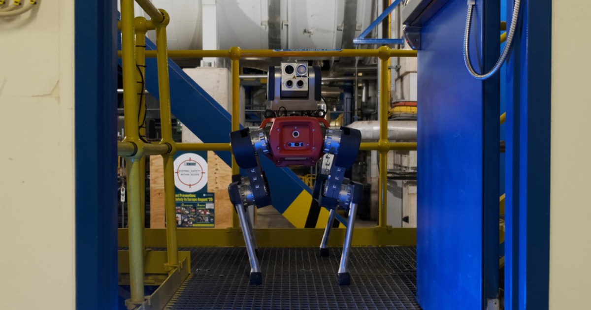 El robot cuadrúpedo ANYmal frente a una puerta azul abierta en una instalación industrial, en una fotografía oficial del piloto de Whitegate.
