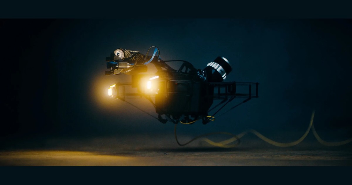 Fotograma oficial del Scout 137 Gen 3 en vuelo, con iluminación encendida, sensores y cable de alimentación bajo el cuerpo.