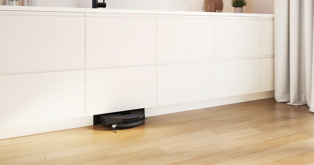 Render oficial de un robot Bosch saliendo por una abertura en el zócalo de una cocina, con la estación oculta en el mueble.