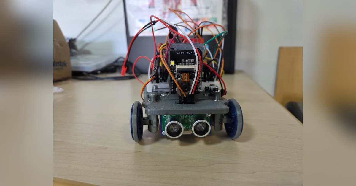 Fotografía de CYBERRCORE del vehículo completo visto de frente, con ultrasonidos, dirección y cableado sobre el chasis.