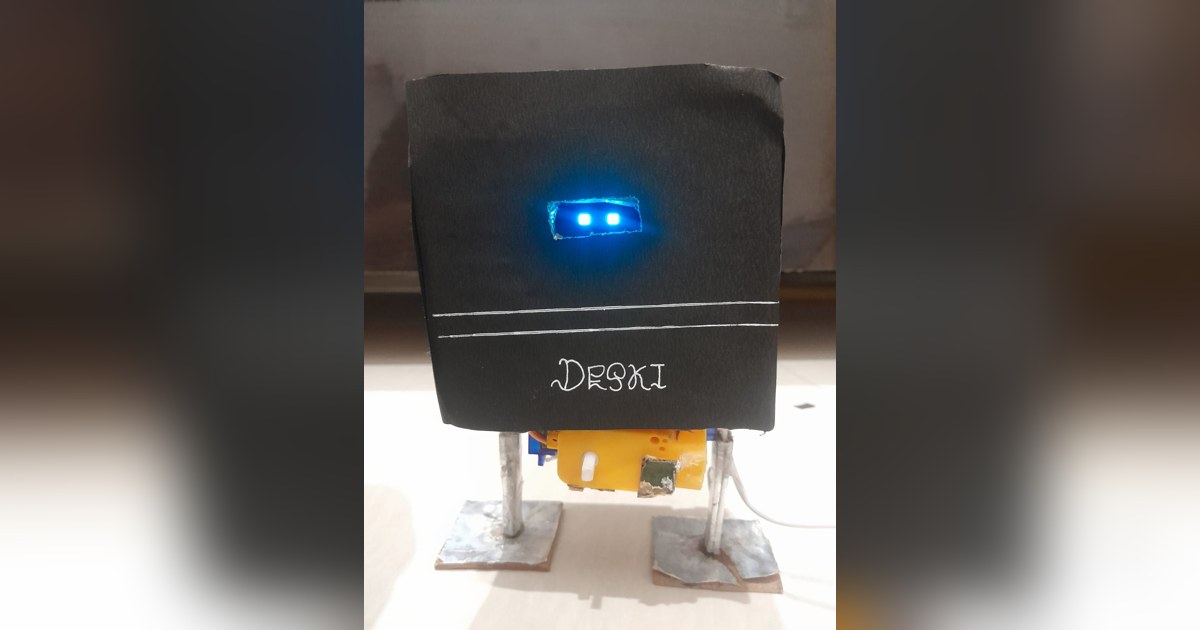 Fotografía de CraftyMind1020 de Deski V1 completo, con carcasa negra artesanal, ojos OLED azules, dos patas y pies planos.