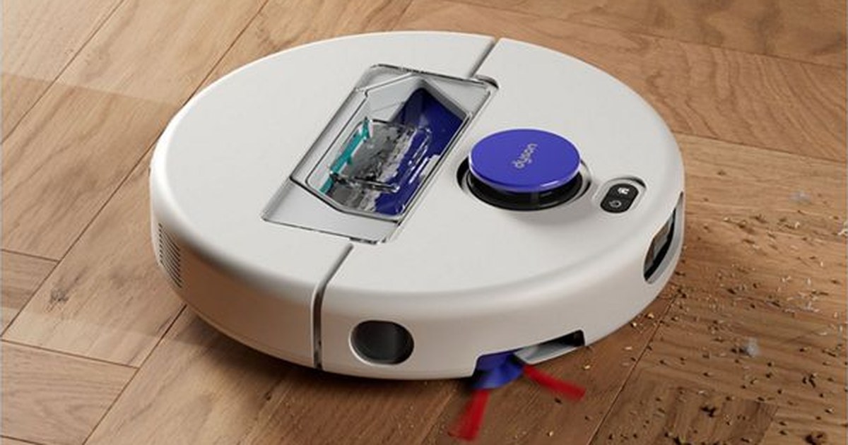 Fotografía oficial del robot aspirador Dyson R1 Nurovi Dry recogiendo residuos sobre un suelo de madera.