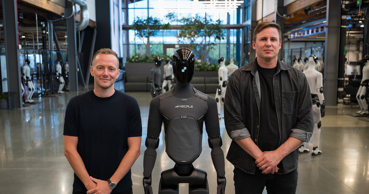 Josh Payne, a la izquierda, y Brett Adcock junto a un humanoide Figure 03 con el logotipo de Nscale, en una fotografía oficial del acuerdo.