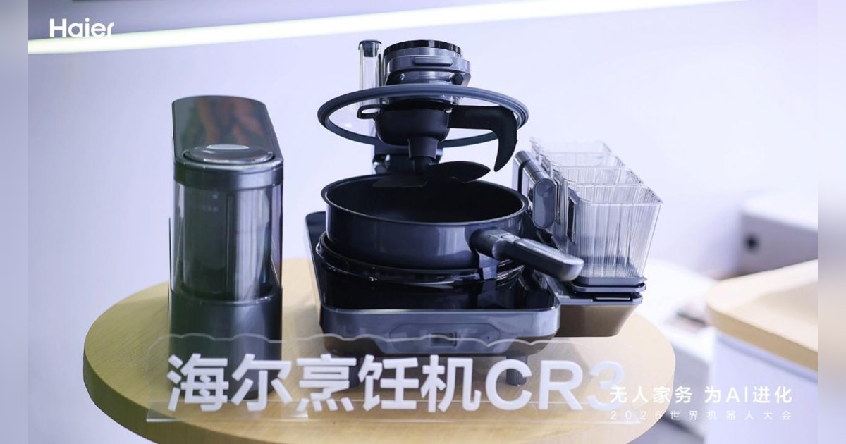 Imagen oficial de Haier del robot de cocina CR3 completo sobre una mesa amarilla, con los módulos de ingredientes y cocción.
