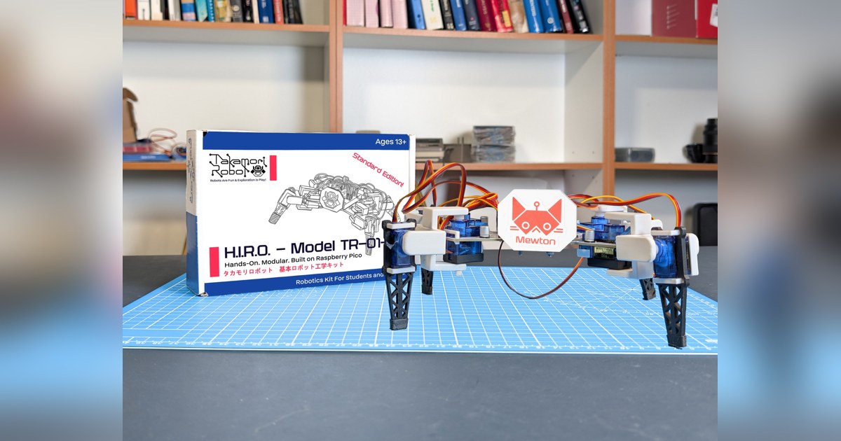 Fotografía oficial de H.I.R.O. TR-01-A completo, con cuatro patas y cuerpo blanco, sobre una mesa de montaje con la caja del kit.