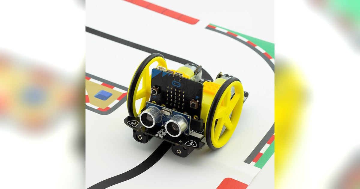 Fotografía de producto del Kitronik :MOVE Motor con una micro:bit montada sobre un circuito de línea negra.