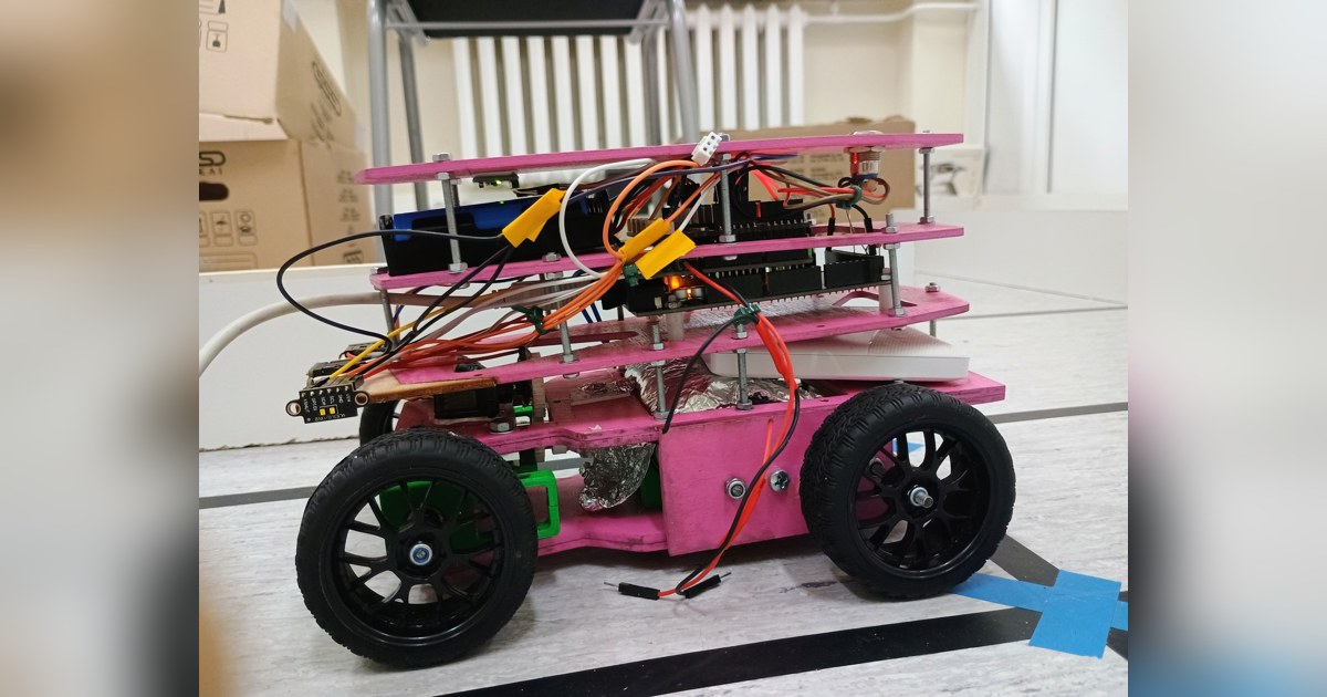 Fotografía de KU STEAM Pinkies de su coche robot completo visto de lado, con chasis rosa por niveles, cuatro ruedas y cableado visible.
