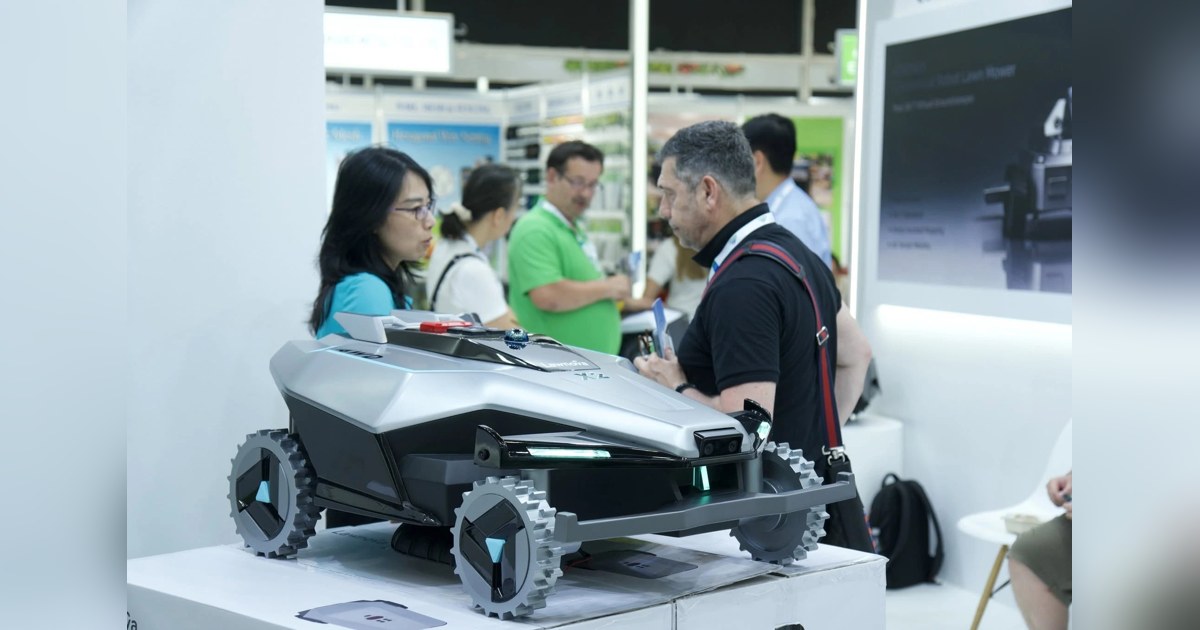 Fotografía oficial del prototipo Lawnova X2 completo expuesto en spoga+gafa 2026, con visitantes del stand al fondo.