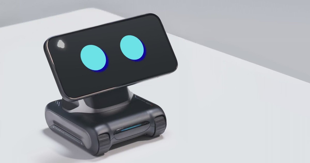 Fotograma oficial de un LOOI negro sobre una mesa blanca, con un teléfono en horizontal que muestra dos ojos azules.