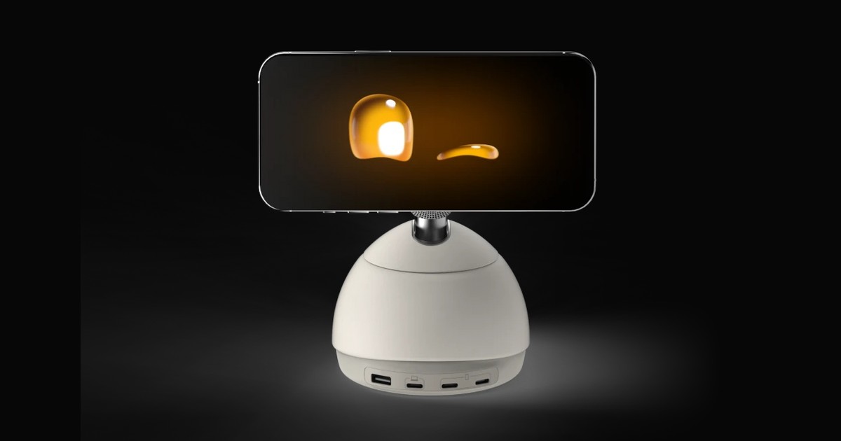 Imagen de producto oficial de Loona Deskmate Studio White, con un iPhone horizontal que muestra un ojo amarillo abierto y otro cerrado sobre la base motorizada blanca.