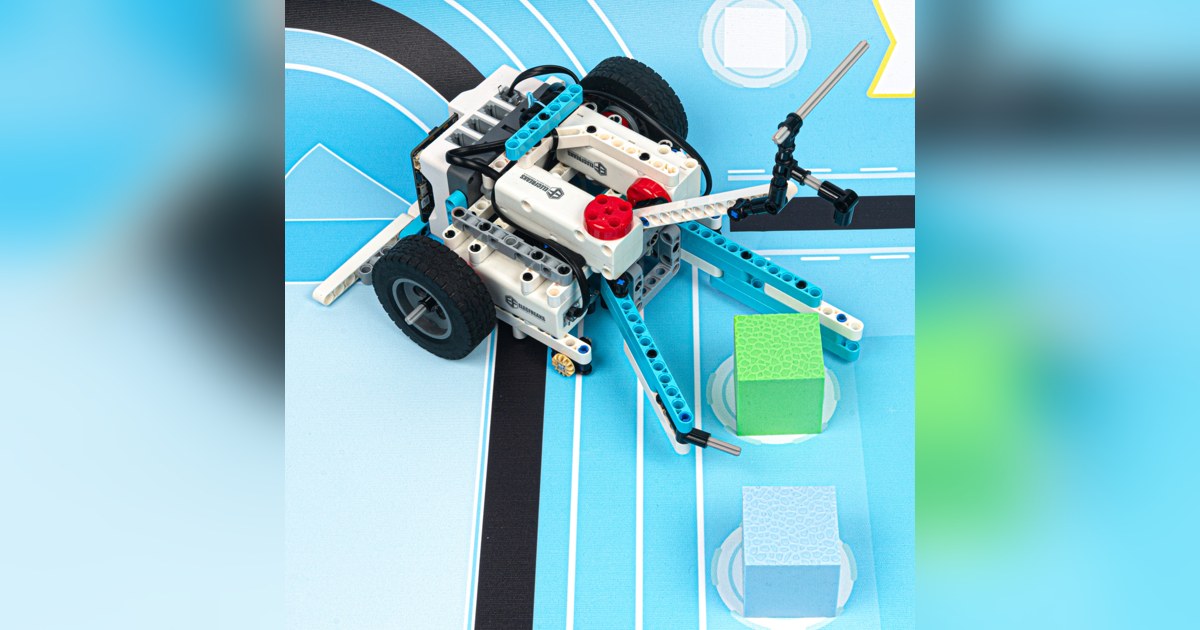 Robot con ruedas construido con Nezha Pro Sports Kit, sobre una pista de seguimiento de líneas.