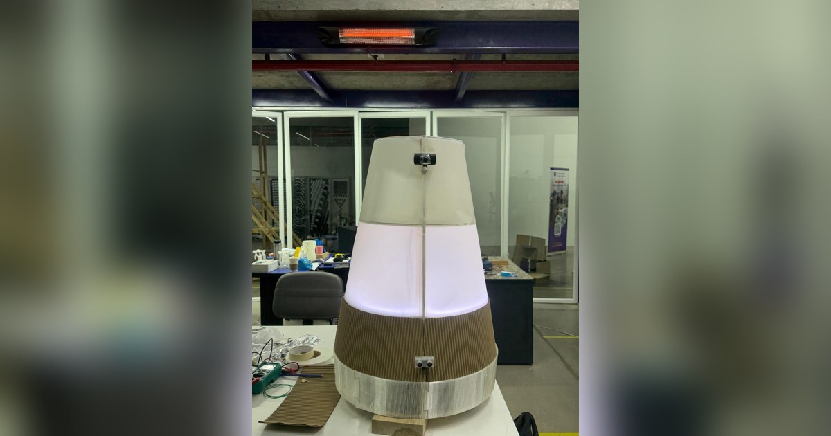 Fotografía de Nicolas Lara del robot completo, con cuerpo de madera y cubierta translúcida iluminada sobre su base móvil.