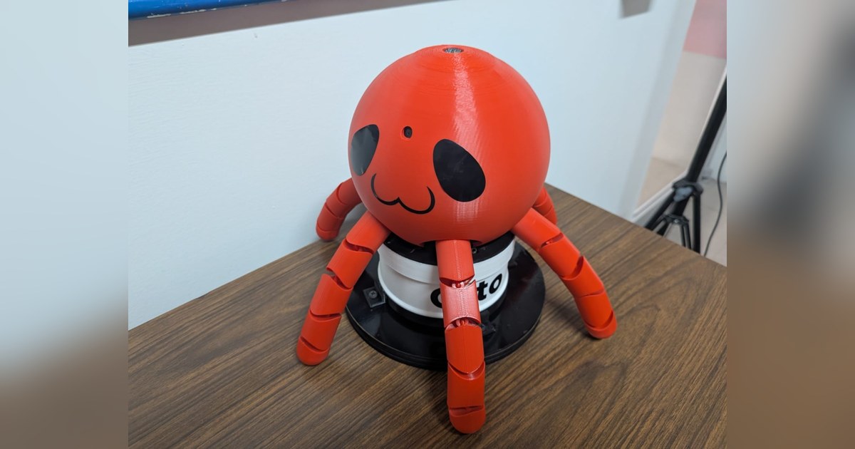 Fotografía de Daniel Peña Cruz de Otto completo, con cuerpo de pulpo rojo y base giratoria negra sobre una mesa.