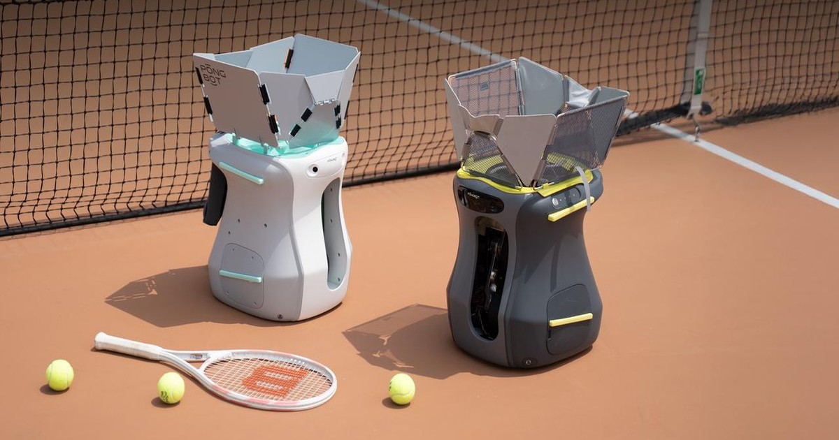Imagen oficial de dos robots lanzapelotas Pongbot Aura, blanco y gris, colocados junto a una red en una pista de tenis.