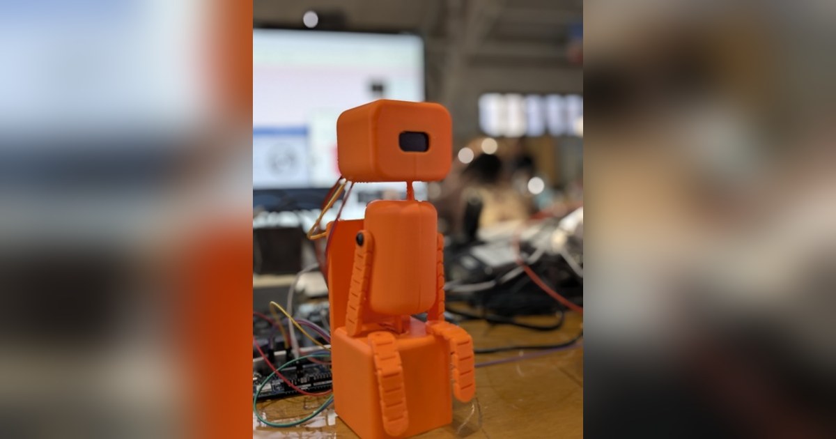 Fotografía del equipo Posture Pet del robot completo, con cuerpo de bloques naranjas, articulaciones y cara OLED.