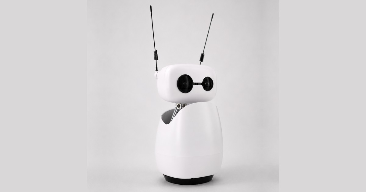 Fotografía oficial de Reachy Mini Wireless blanco visto de tres cuartos, con las antenas negras y la base completa sobre fondo gris.
