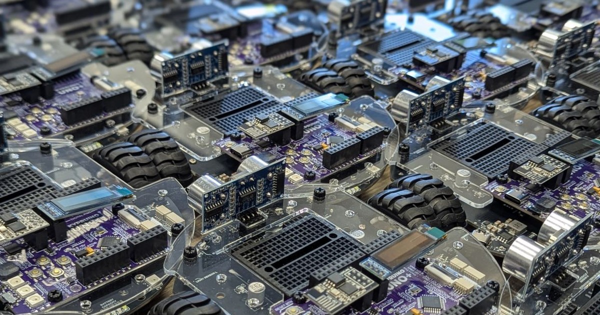 Fotografía oficial de varias unidades físicas de RoboRover Core V3.1 alineadas sobre una mesa, con ruedas negras, placas moradas y sensores ultrasónicos visibles.