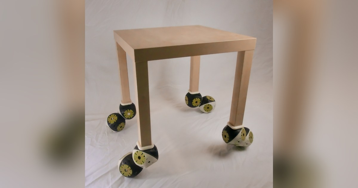 Mesa experimental equipada con módulos Roombots en sus cuatro patas, publicada por EPFL BioRob.