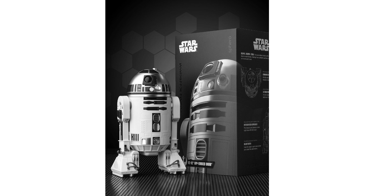 R2-D2 de Sphero fotografiado junto a su caja, con cabeza y tres apoyos visibles.