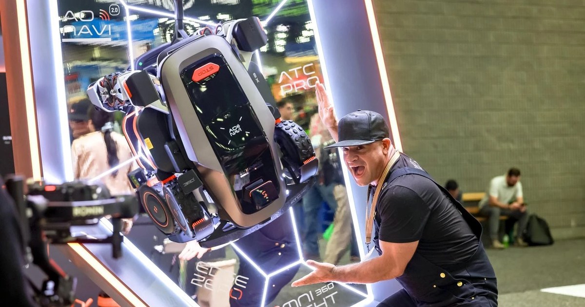 Fotografía oficial de Sunseeker: el cortacésped X8 expuesto en posición inclinada junto a un visitante en Equip Expo 2026.