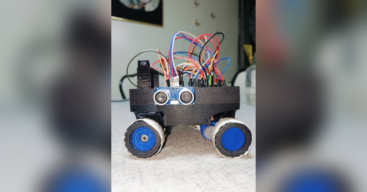 Fotografía de Vitality de su coche robot completo, con cuatro ruedas azules, electrónica visible y sensor ultrasónico lateral.