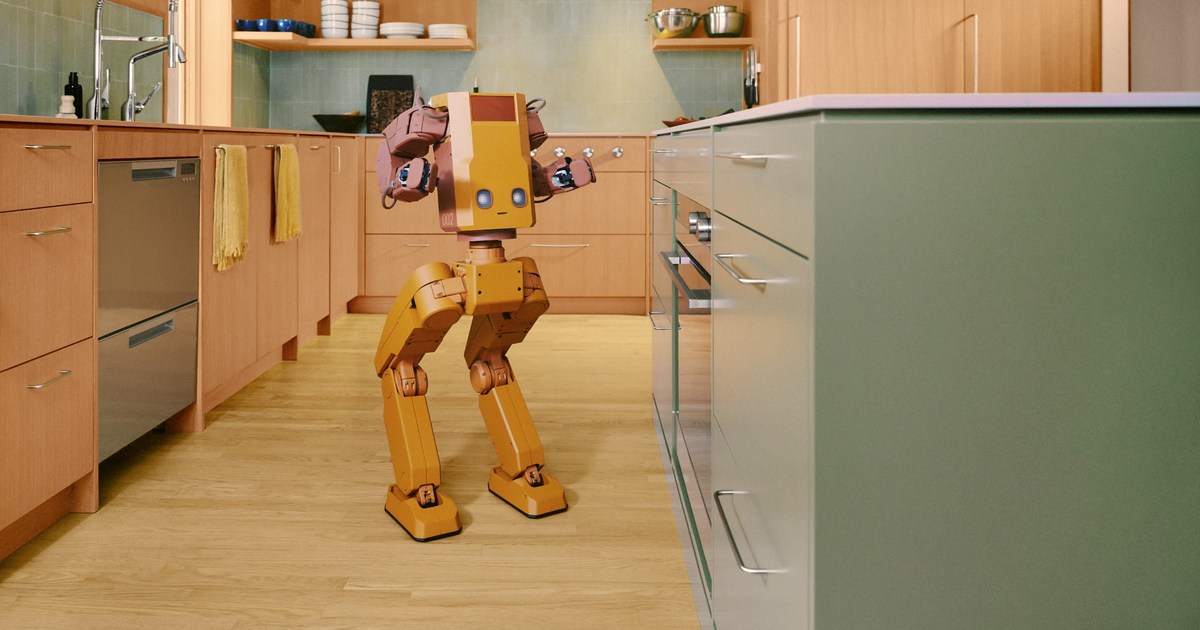 Fotografía oficial del prototipo Voxel, con cuerpo amarillo, brazos rosados y dos piernas articuladas, de pie en una cocina.