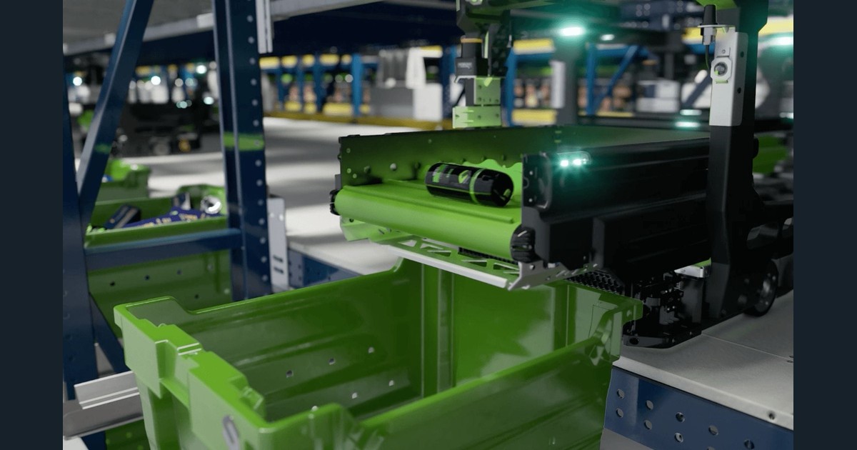 Fotografía oficial de Symbotic: un robot BreakPack Mini Bot con una cinta verde transporta un envase sobre una cubeta, entre estructuras azules del sistema.