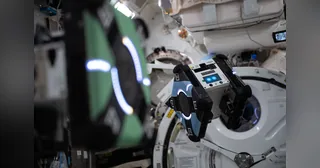 Un robot cúbico Astrobee fotografiado dentro de la Estación Espacial Internacional.