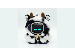 Fotografía oficial de EMO con ojos azules en su pantalla y un disfraz de vaca blanco y negro, sobre fondo claro.