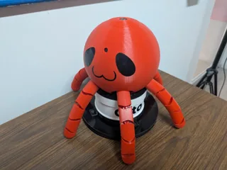 Fotografía de Daniel Peña Cruz de Otto completo, con cuerpo de pulpo rojo y base giratoria negra sobre una mesa.