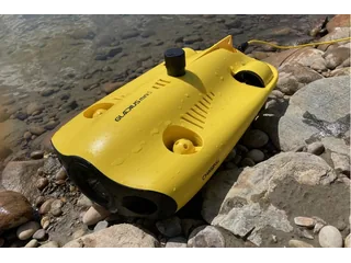 GLADIUS MINI S amarillo completo sobre rocas junto al agua, con su cable conectado.