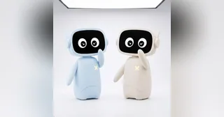 Dos robots físicos XiaoMu en azul y crema sobre un escritorio