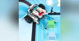 Robot con ruedas construido con Nezha Pro Sports Kit, sobre una pista de seguimiento de líneas.