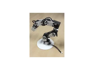Brazo Poppy Ergo Jr con piezas blancas impresas en 3D y motores transparentes sobre una mesa de madera