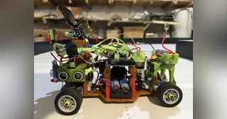 Fotografía del Team NEDrobotics de su coche robot completo, con piezas impresas verdes, ruedas negras, ultrasonidos y electrónica visible.