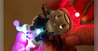 Ringo sostenido en una mano con sus motores y luces RGB encendidos.