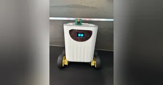 Fotografía de cyrixninja de Mizuna completo, con cuerpo de caja blanca, cuatro ruedas, cara OLED y cámara sobre el cuerpo.