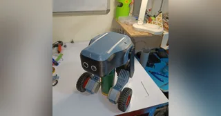 Fotografía de kairobyte del robot completo ensamblado, con dos patas y ruedas, apoyado sobre el banco de trabajo.