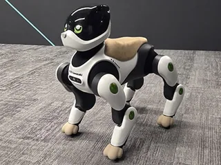 Fotografía oficial del prototipo Home LEO de Kawasaki, blanco y negro, con cuatro patas y hocico frontal.