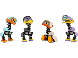 Cuatro Microduck de Pollen Robotics en distintos colores y posturas sobre fondo blanco.