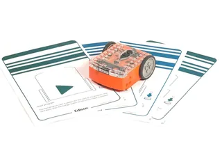 Fotografía oficial de Edison V3, con carcasa naranja y cubierta transparente, sobre tarjetas de programación con códigos de barras.