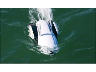 PowerDolphin blanco y azul completo navegando sobre el agua, con su cámara frontal visible.