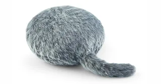 Cojín Qoobo de color gris con su cola robótica extendida