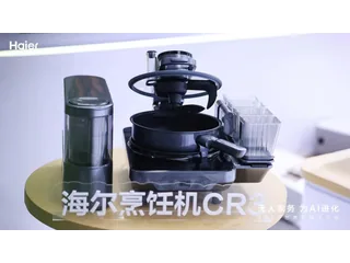 Imagen oficial de Haier del robot de cocina CR3 completo sobre una mesa amarilla, con los módulos de ingredientes y cocción.