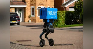 IRIS completo con una caja azul de Evri, dos patas articuladas y ruedas en una calle residencial de Barnsley.