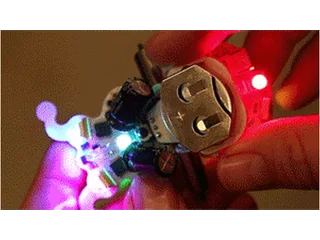 Ringo sostenido en una mano con sus motores y luces RGB encendidos.