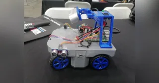 Fotografía del Equipo Octobots de Octoneer completo, con cuerpo gris, cuatro ruedas azules y un soporte elevado de componentes.