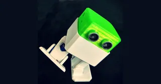 Fotografía oficial de un Otto DIY montado, con cabeza verde translúcida, sensor ultrasónico frontal, cuerpo y pies blancos sobre fondo oscuro.