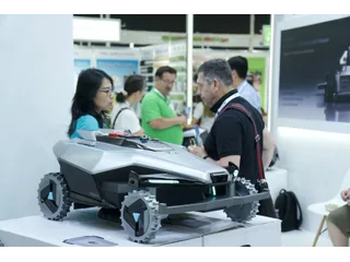 Fotografía oficial del prototipo Lawnova X2 completo expuesto en spoga+gafa 2026, con visitantes del stand al fondo.