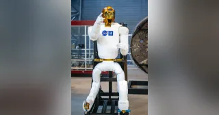 Robonaut 2 completo en un soporte de exposición, con cabeza, torso, ambos brazos y sus dos miembros de movilidad visibles.